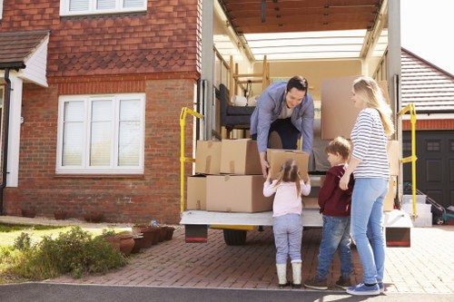 Specialist movers preparing a piano for transport on a residential street in Watford