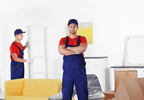 Professional movers carrying furniture in a Watford residential property