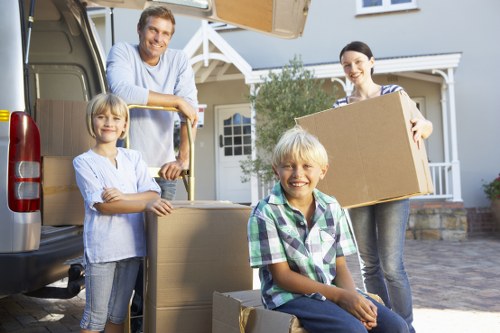 Professional movers carrying furniture from a Watford flat